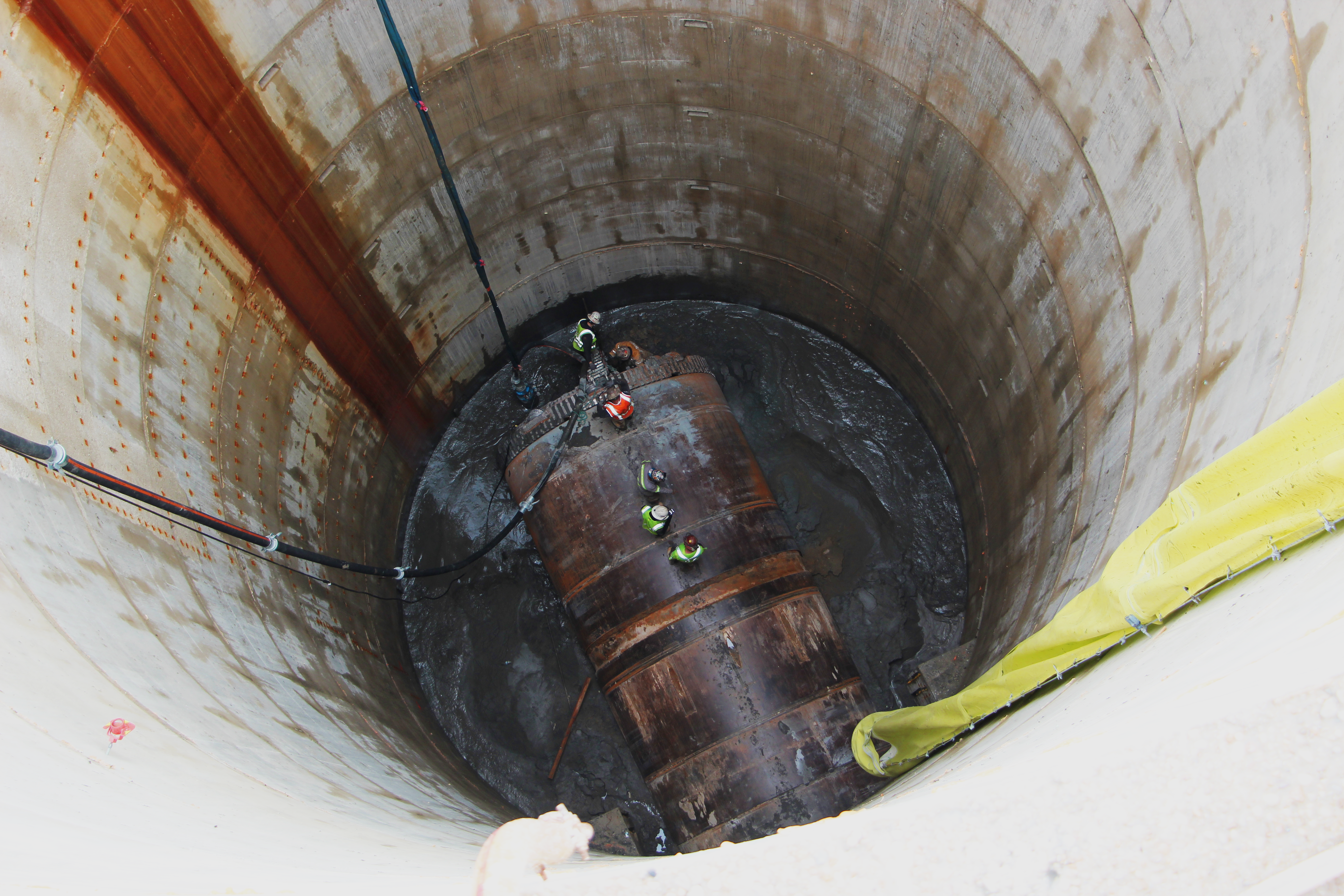 Looking down the shaft of workers standing on and around Hazel, the tunnel boring machine. 