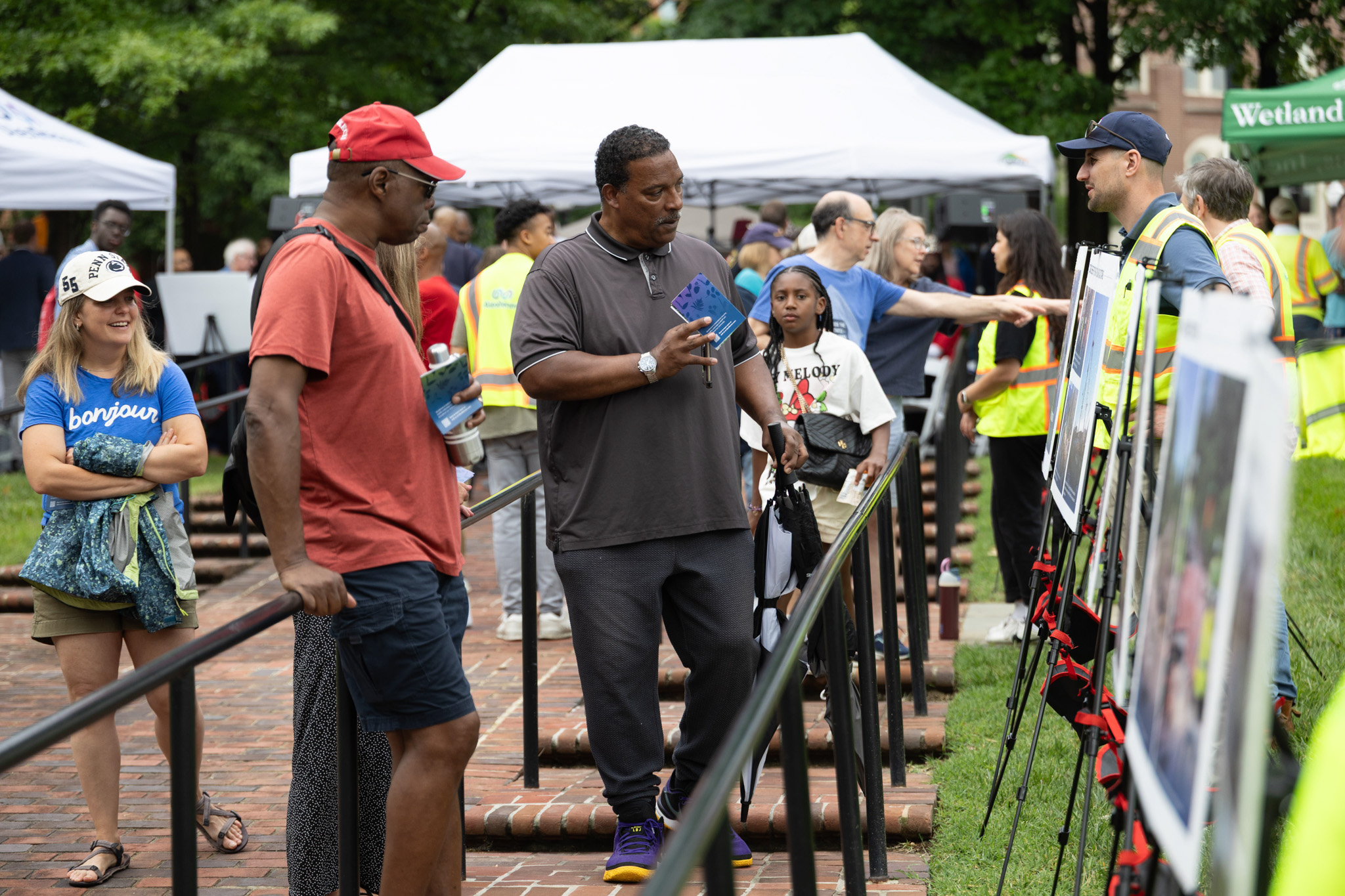 Two Black men examine a sign explaining RiverRenew