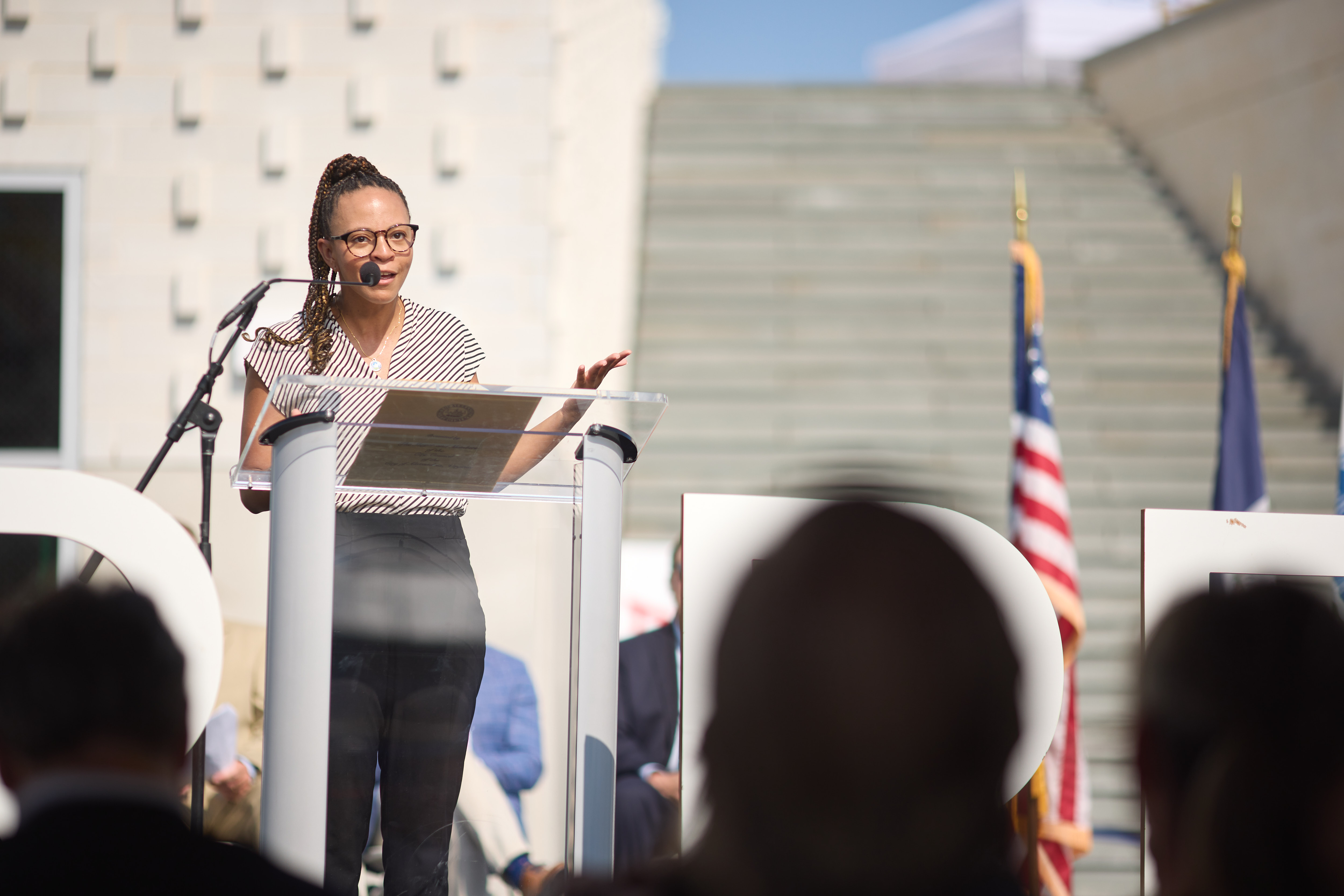 a woman speaks at the podium